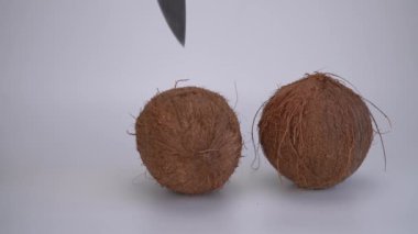 Hindistan cevizi ikiye bölünmüş bir bıçakla. Coco, olgun palmiye meyvesi. fındık faydalıdır, birçok hastalıkta vücudun durumunu iyileştirir..