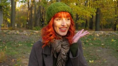 Sonbahar parkında kızıl saçlı kız.