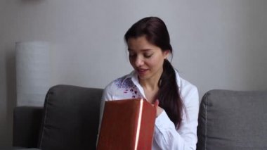 Kız evde hediyelerle oynuyor.