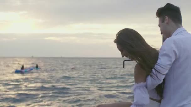 A girl and a guy at sea at dawn — Stock Video