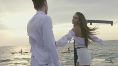 Bir kız ve bir erkek şafakta denizde.