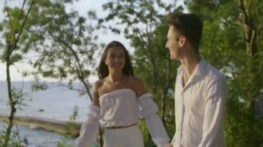 Bir kız ve bir erkek şafakta denizde.