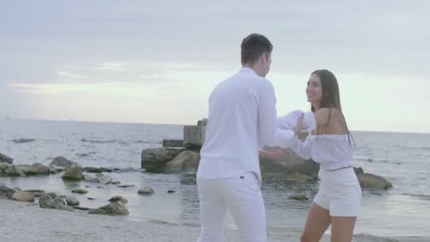 Una chica y un chico en el mar al amanecer — Vídeos de Stock