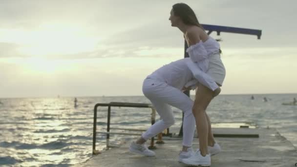 Dziewczyna i facet na morzu o świcie — Wideo stockowe