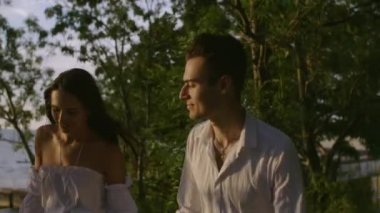 Bir kız ve bir erkek şafakta denizde.