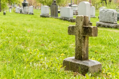 Ön planda bir haç ile mezarlığa birçok mezar taşı
