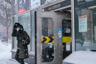 Montreal, CA - 2 Şubat 2021: Laurier metro istasyonundan koruyucu yüz maskeli kadın geliyor