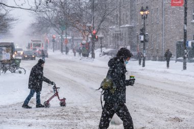 Montreal, CA - 2 Şubat 2021: Şiddetli kar yağışı sırasında koruyucu maskeli insanlar sokakta yürüyor
