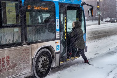 Montreal, CA - 2 Şubat 2021: Kar fırtınası sırasında STM otobüsüne binen yolcu