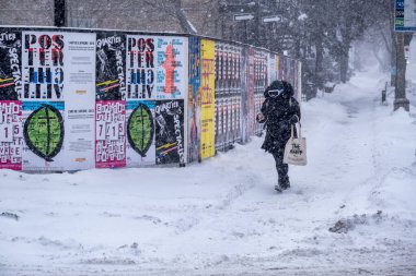 Montreal, CA - 2 Şubat 2021: Şiddetli kar yağışı sırasında sokakta yürüyen kadın