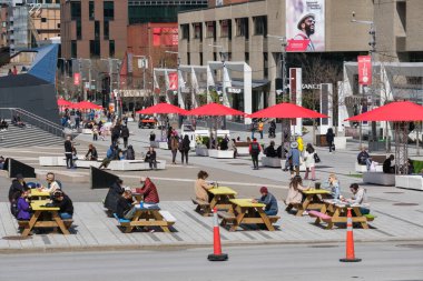 Montreal, CA - 6 Mayıs 2021: Montreal şehir merkezindeki St. Catherine Caddesi 'nde piknik masalarında oturan insanlar.