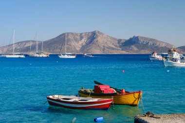 Ano Koufonisi, GR - 9 Eylül 2025: Arka planda yerleşim olmayan Keros Adası ile birlikte birçok renkli tekne denize demirlemiştir