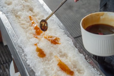 Şeker kulübesinde kar üzerinde akçaağaç şekeri. Quebec, Kanada 'da