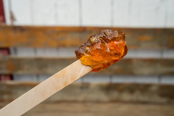 Maple taffy on a stick during sugar shack period — Stock Photo, Image