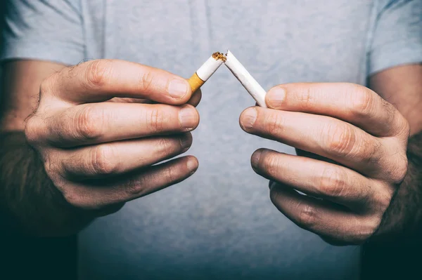 Quitting smoking - male hand crushing cigarette — Stock Photo, Image