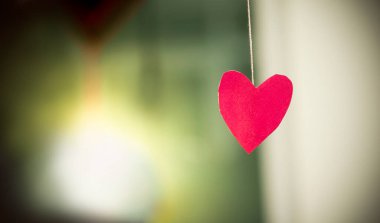 Kalp şeklinde, arka planda pembe kağıt, pembe kalp şeklinde kağıt, aşkın havasını ifade eden bir atmosferde asılı..