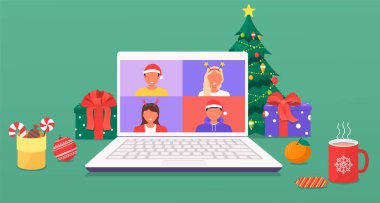 Noel ve Yeni Yıl evlerinde Noel ağacı, süslemeler, hediyeler, baston kurabiyeler ve şekerler, kahve, dizüstü bilgisayarlar. Meslektaşlar bilgisayar ekranında video çağrısı yoluyla birbirleriyle konuşurlar..