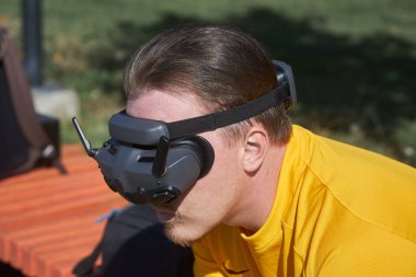 Kahverengi saçlı bir adam uzaktan uçuş deneyimi için drone FPV gözlük takıyor. Eğlence için teknoloji ve sanal gerçeklik.