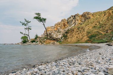 Baykal Gölü kıyısındaki Rocky çakıl taşı plajı. Sibirya 'daki Olkhon Adası' nın güzel doğası. Yaz seyahati ve doğal manzara için turizm kavramı.