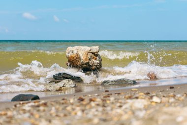 Dalgalar Sibirya 'daki Baykal Gölü' nün kumlu kıyısı boyunca kayalara çarpıyor, doğal olarak el değmemiş seyahat turizmi manzarası.