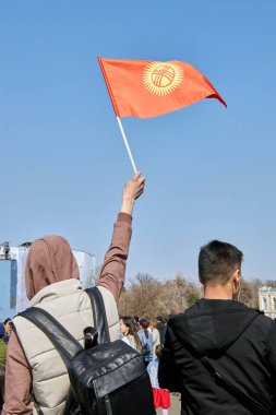 Nooruz kutlamasında Kırgızistan bayrağı taşıyan adam. İnsanlar Bahar Bayramı festivali için Bishkek 'te toplanıyorlar. Kültürel gelenek, ulusal gurur, toplum etkinliği. Bishkek, Kırgızistan - 21 MAR 2023.