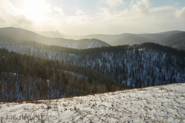 Kar, güneşli bir kış gökyüzünün altında orman tepeleriyle kaplıydı. Arka plan ya da doğa takvimi için ideal kış manzarası. Sakin mevsimlik sahne.