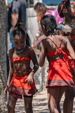 Kültürel performans için yüzünü boyayan geleneksel kostümlü Afrikalı bir kız. Kültürel etkinlik ve turist bağış konsepti için eğlence. Cape Town, Güney Afrika - 22 OCT 2023