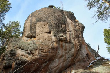 Geniş doğal kaya oluşumu ve engebeli dokusu açık bir gökyüzüne karşı. Seyahat ve macera temaları için doğa manzarası. Stolby Parkı, Krasnoyarsk. Tırmanma alanı.