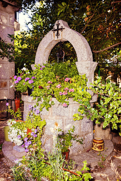 stone well for water decorated with flowers