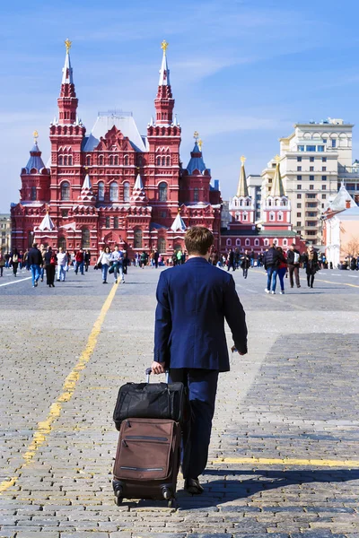 Um homem com uma mala na Praça Vermelha em Moscou contra o ba — Fotografia de Stock