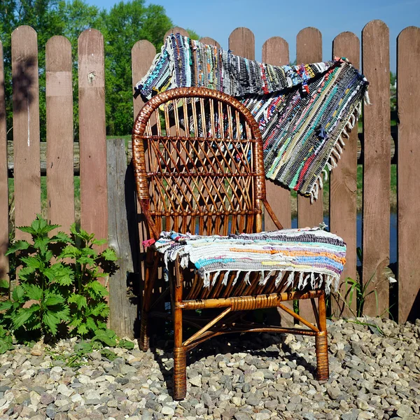 Chaise en osier sur la clôture en bois — Photo