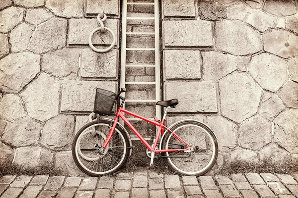 Red bicycle on a background of a stone wall — Stock Photo, Image