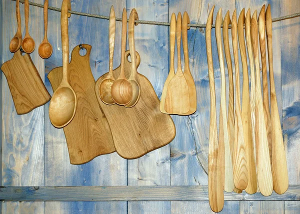 Обробні дошки та дерев'яні ложки, що висять на стіні, посуд — стокове фото