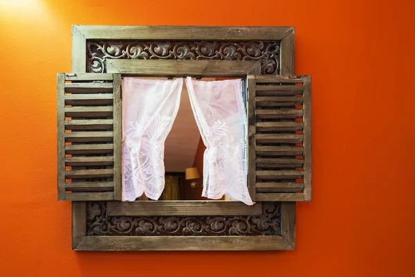 Miroir dans un cadre sculpté en bois sur un mur orange — Photo