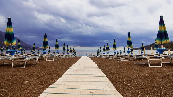 Székek és napernyők a strandon, mielőtt a vihar — Stock Fotó