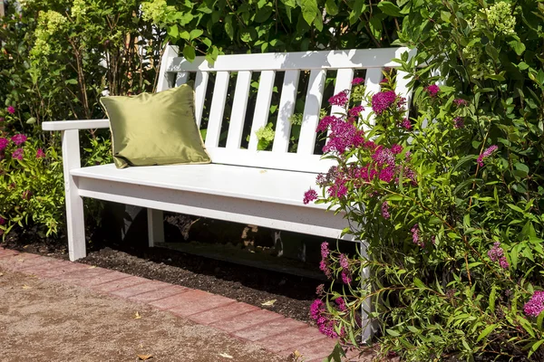 Banc blanc dans le jardin luxuriant — Photo