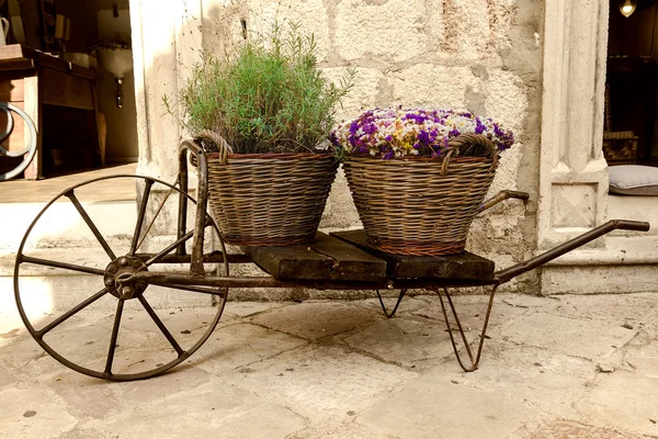 Старий інвалідний візок з кошиками квітів — стокове фото