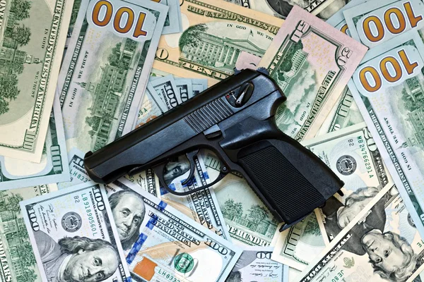 Black gun against the background of US dollars — Stock Photo, Image