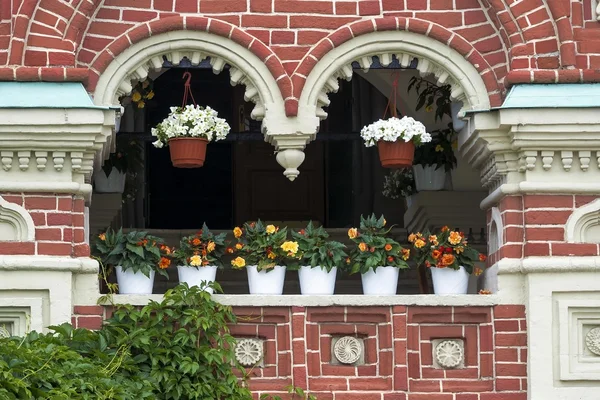 Backsteinmauer mit Blumen dekoriert — Stockfoto