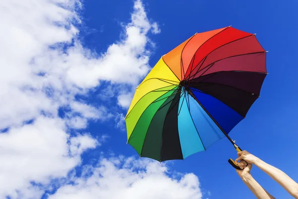 Paraguas multicolor en la mano en el cielo de fondo —  Fotos de Stock