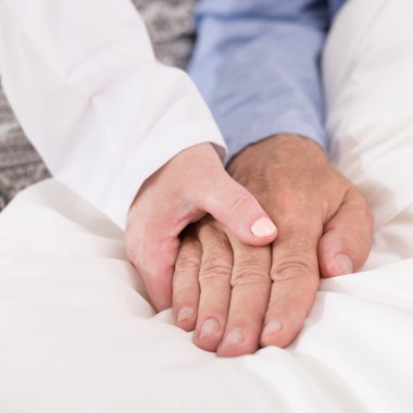 Hasta adamın elini tutarak