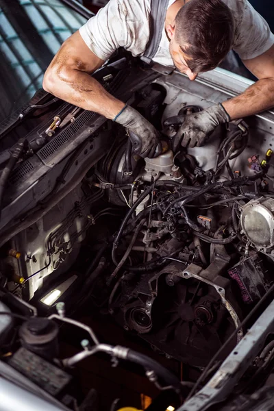 Homme travaillant sous capot de voiture — Photo