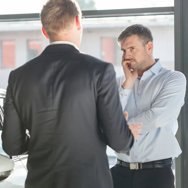 Mature client in car showroom — Stock Photo, Image