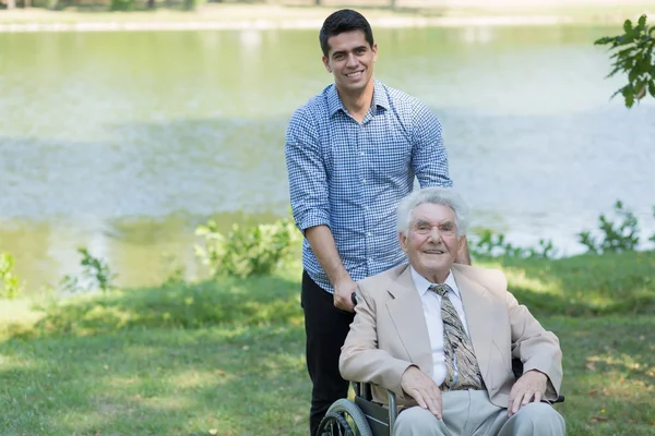 Homme âgé handicapé et petit-fils — Photo