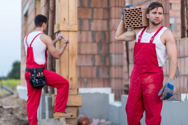 Constructores en ropa de trabajo que trabajan duro — Foto de Stock