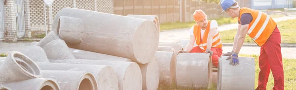 Bouwers met betonnen buizen — Stockfoto