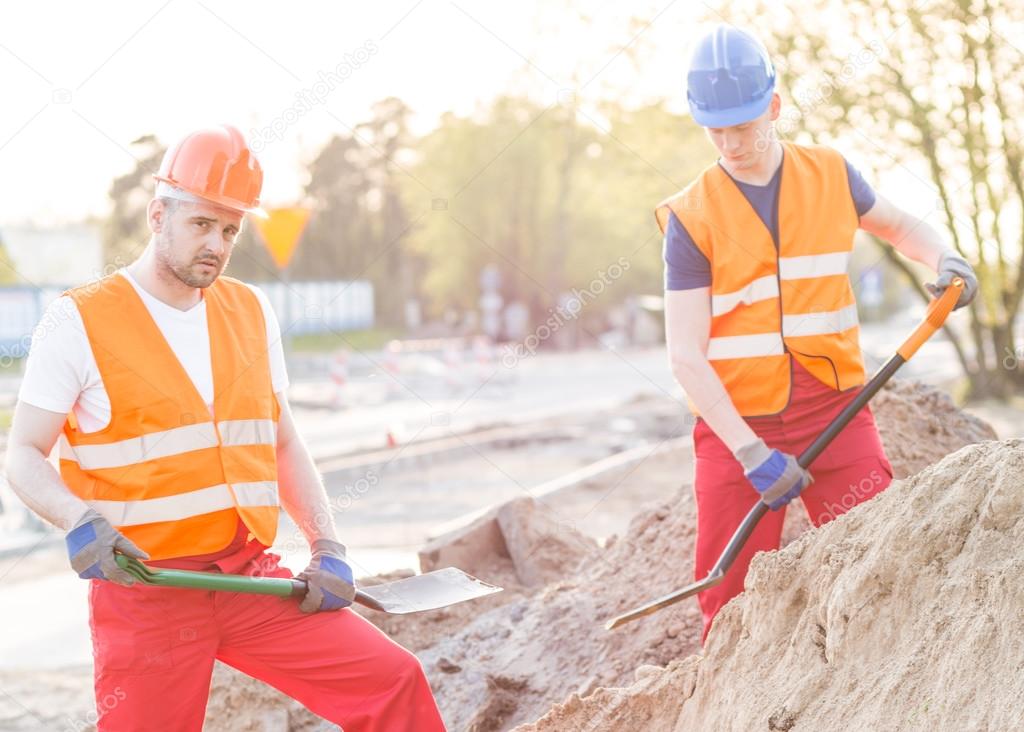 Workers standing with shovels 