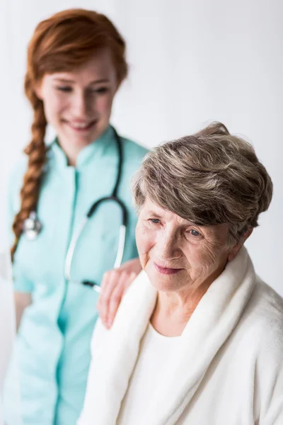 Doctor helping ill elderly patient — Stock Photo, Image