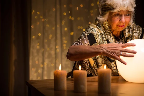 Frau blickt in Kristallkugel — Stockfoto