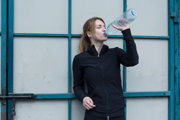 Jente i sportsdress med vann – stockfoto